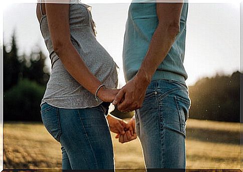 Pregnant woman with her husband in the field thinking about the crisis in stable couples