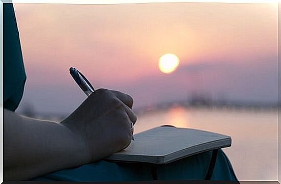 woman writing at sunrise symbolizing the art of expressing emotional pain