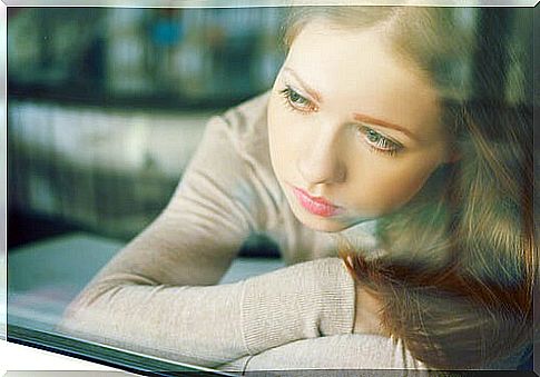 Girl looking at window feeling fear, sadness and frustration