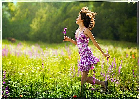 Woman walking among flowers smiling and happy