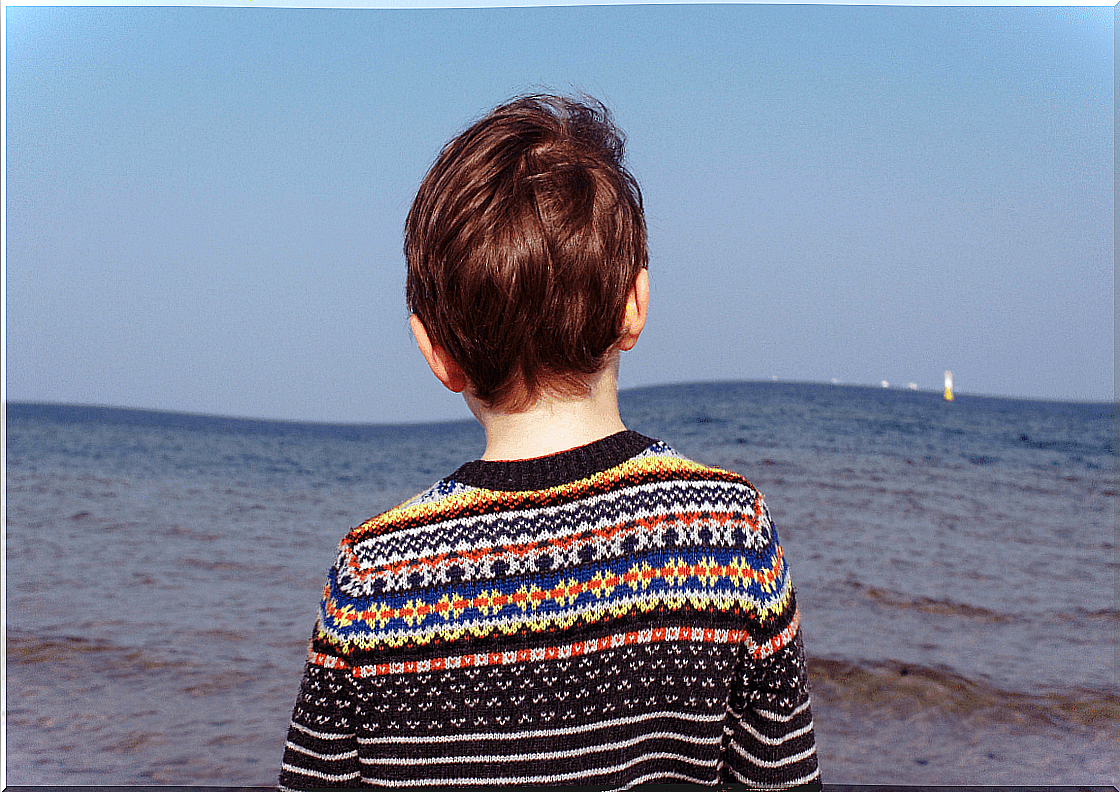 Boy on his back with the sea in the background