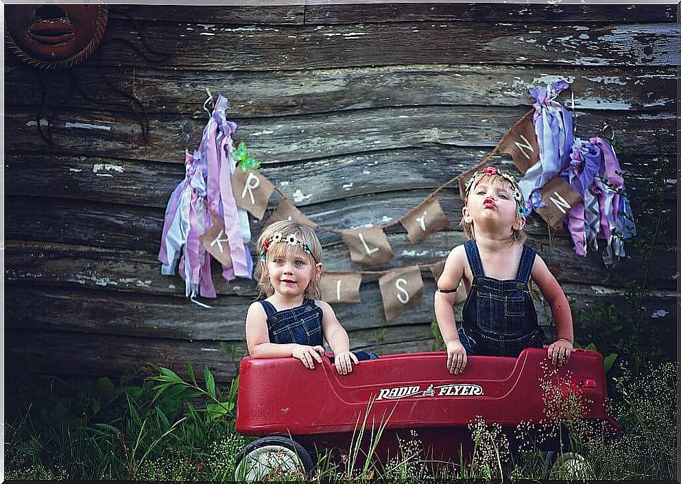 Two little sisters in a toy wagon