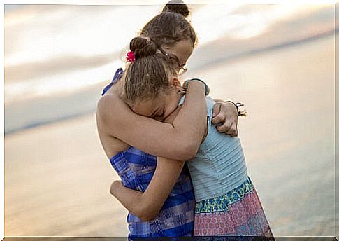 Sisters hugging on the beach