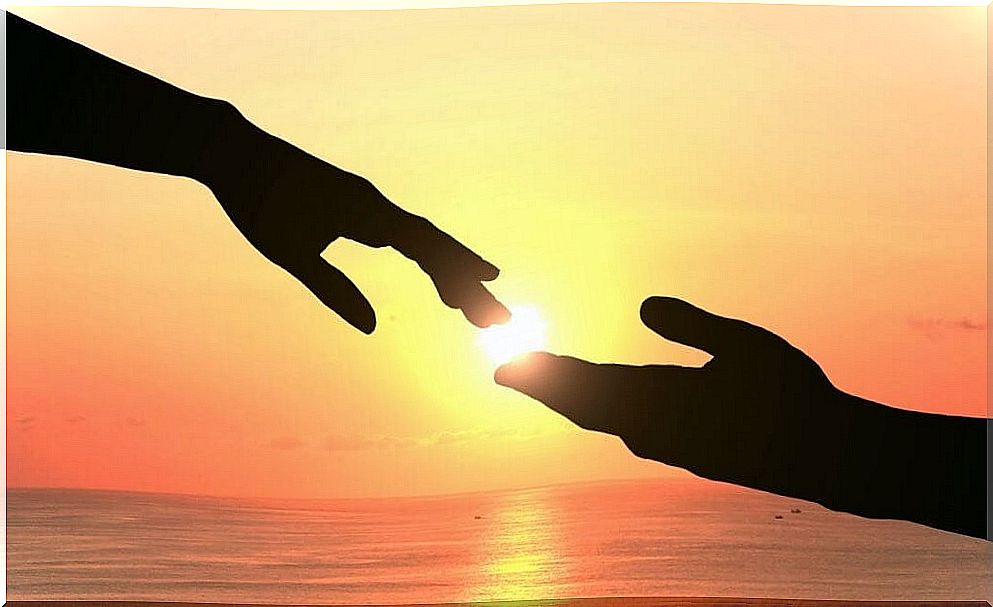 Hands touching at sunset