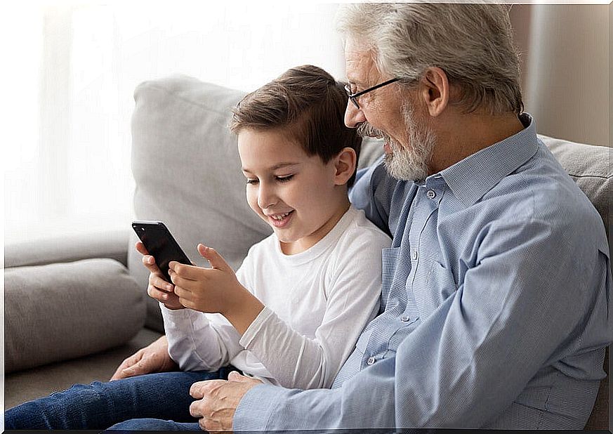 Grandson teaching his grandfather to use the mobile